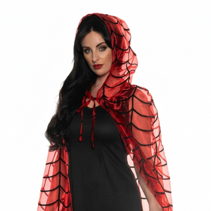 A woman modeling a black maxi dress with a sheer red and black spiderweb-patterned hooded cape on a white studio background.
