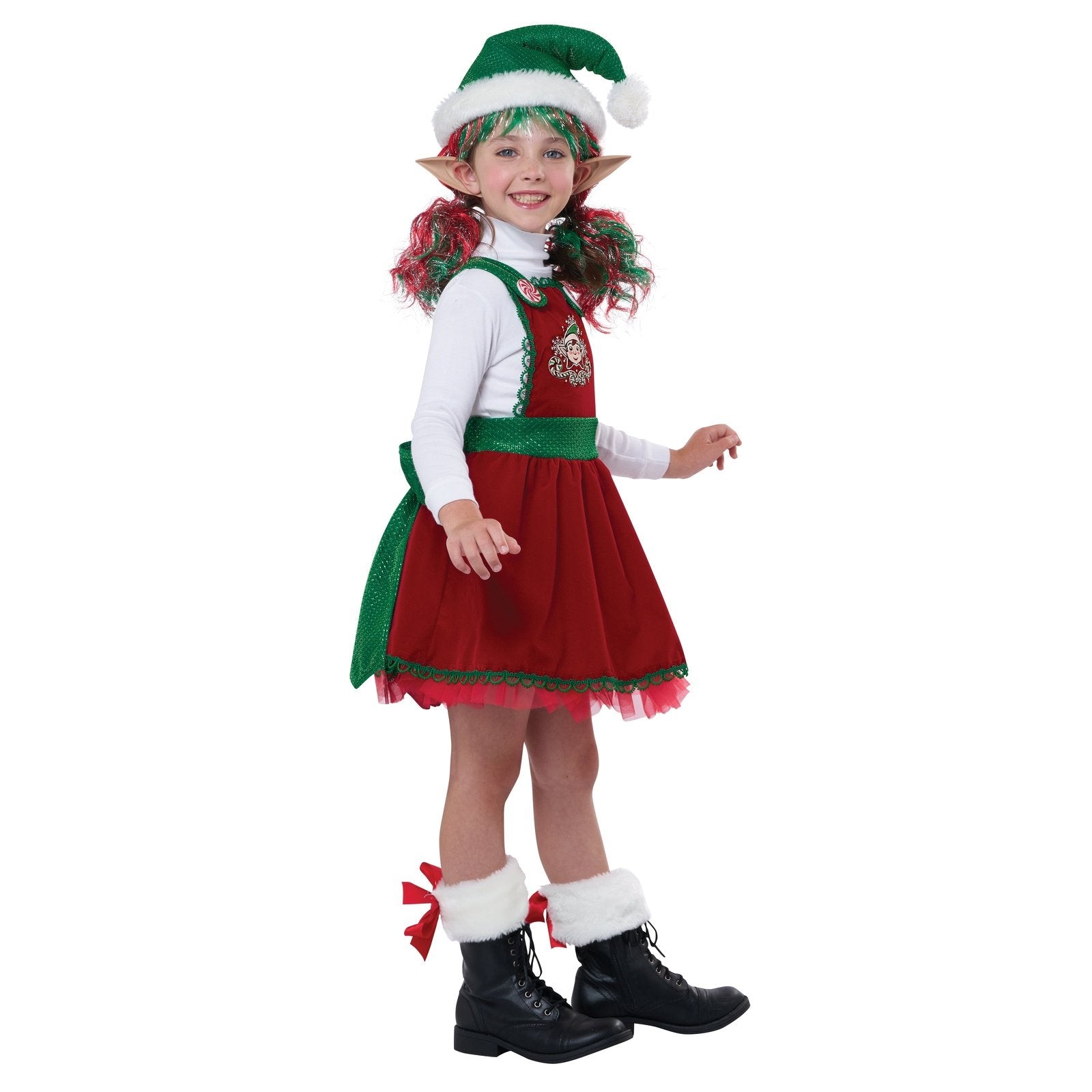 A smiling child dressed as an elf holds a candy cane