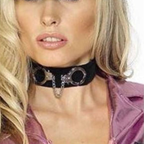 A blonde woman wearing a black choker collar with a metal handcuff design and a small silver hanging charm, along with a black cap and a shiny mauve top against a white background.