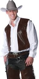 Man wearing the Cowboy Chaps Men's Costume showing a dark brown faux suede fringed vest over a white long-sleeve shirt with a grey cowboy hat on a white background