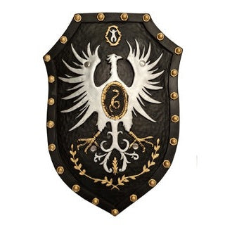 50cm leather-look knight shield in black with gold stud border detail, featuring a white heraldic eagle crest with gold medallion centre, gold laurel wreath, and decorative scrollwork, shown as a wall display prop