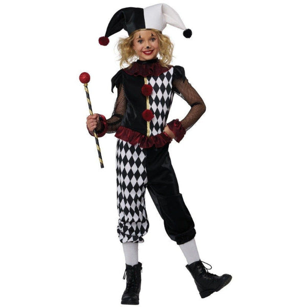 A child modeling a black and white harlequin jester costume, holding a jester staff. The costume features a black and white patterned hat, a black and white patterned vest, black pants, white socks, and dark red ruffle accents.