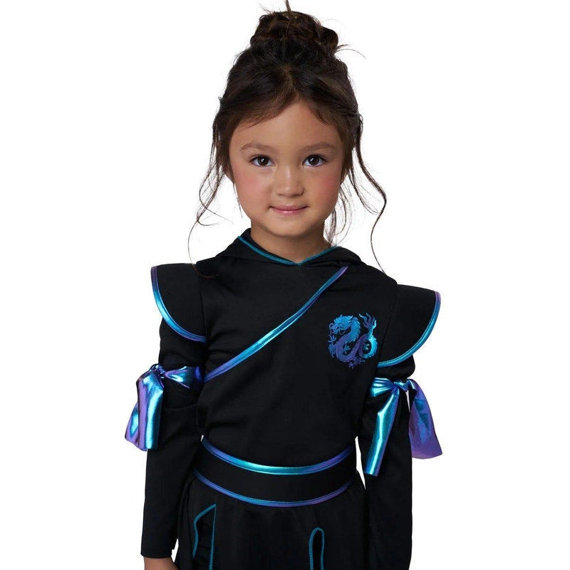 A young girl modeling a black costume dress with metallic blue and purple trim, featuring a dragon emblem on the chest, set against a plain white background.