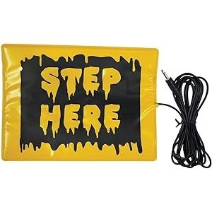 Large black and yellow rectangular Step Here Pad with white text