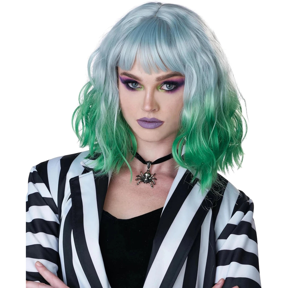 A model wearing a short, wavy wig with a silver-gray top that fades into bright green at the ends, styled with a straight fringe. The model is also wearing a black and white striped blazer, a black top, and a black spider choker against a plain white background.