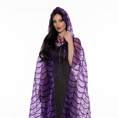 A woman modeling a purple hooded cloak with a black dragon-scale pattern, worn over a black dress against a plain white studio background.