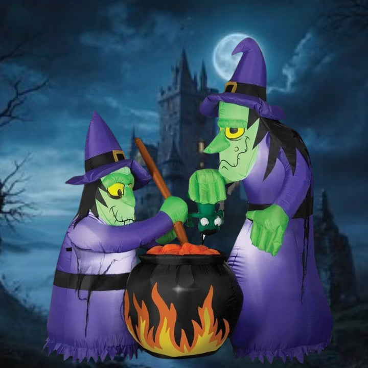 Spooky Halloween decoration featuring two witch inflatables with cauldron