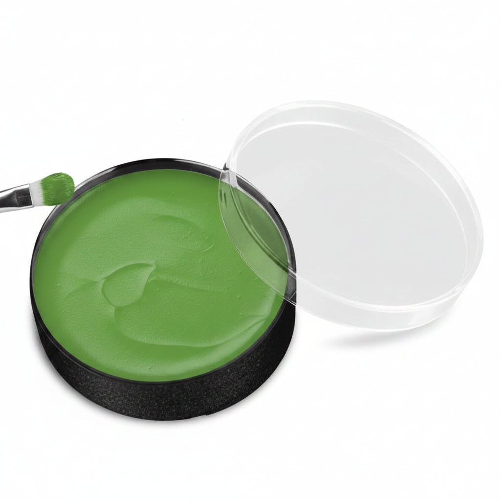 A round makeup pan filled with bright green cream product, shown open with its clear lid resting beside it on a white background.