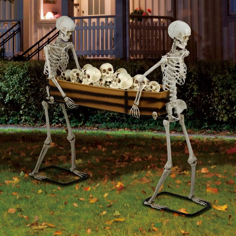 Poseable skeleton with red eyes carrying a coffin in graveyard setting