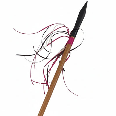 A long wooden look spear or staff with a black pointed tip, wrapped brown sections, and dangling red, cream and brown ribbons, shown on a plain white background.