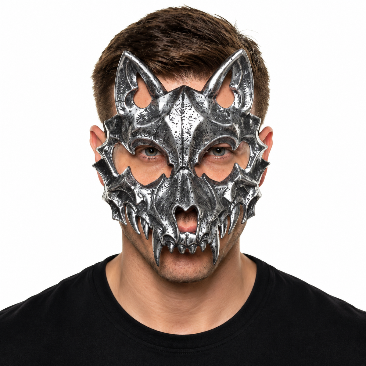 A man wearing a detailed, metallic silver wolf or werewolf mask with sharp teeth and ears, photographed against a solid white background.