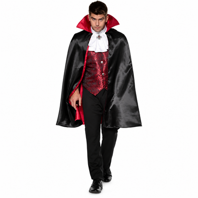 A man modeling a vampire costume consisting of a black satin cape with a red inner lining, a red patterned vest, a white ruffled shirt, and black pants against a plain white background.