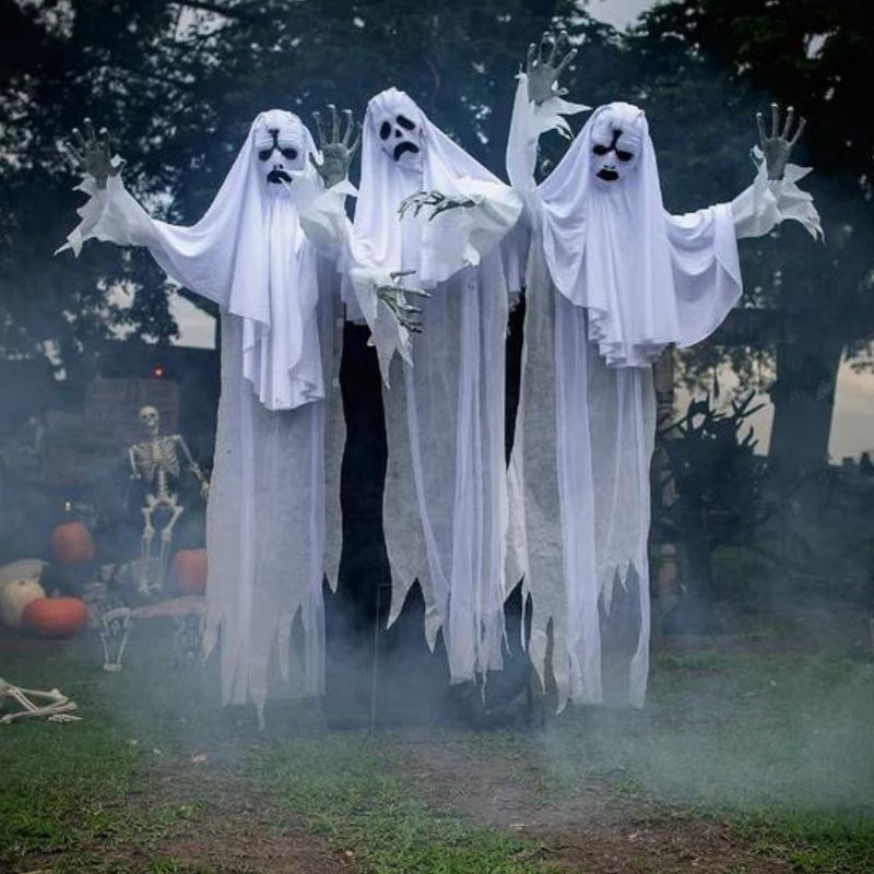 Three spooky, animated ghosts with flowing white sheets and glowing eyes