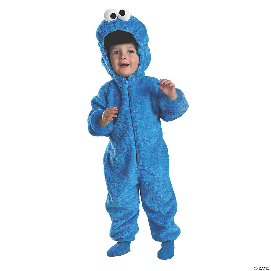 A little boy wearing a blue and fuzzy Deluxe Sesame Street™ Cookie Monster Costume, Toddler, with a big Cookie Monster character headpiece and matching gloves